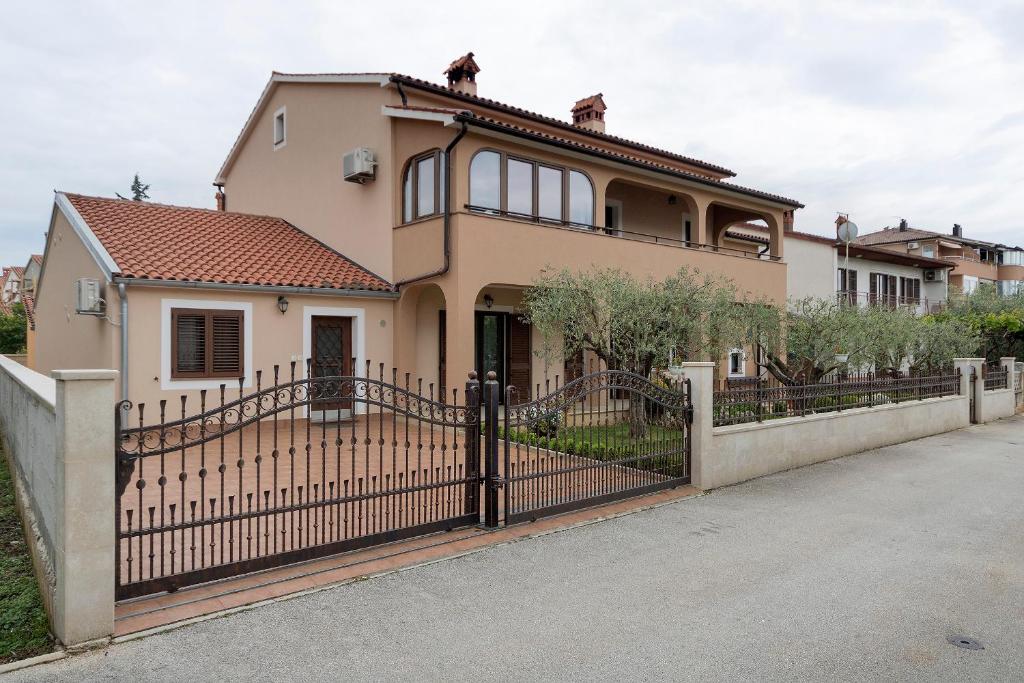 a house with a gate and a fence at Apartments Monte Grande in Pula