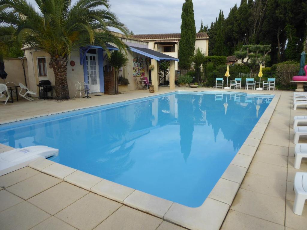 a large swimming pool with chairs and a house at Mas Saint Antoine in Rognonas