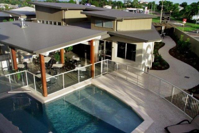 a house with a swimming pool in front of a house at Mary River Motor Inn in Gympie