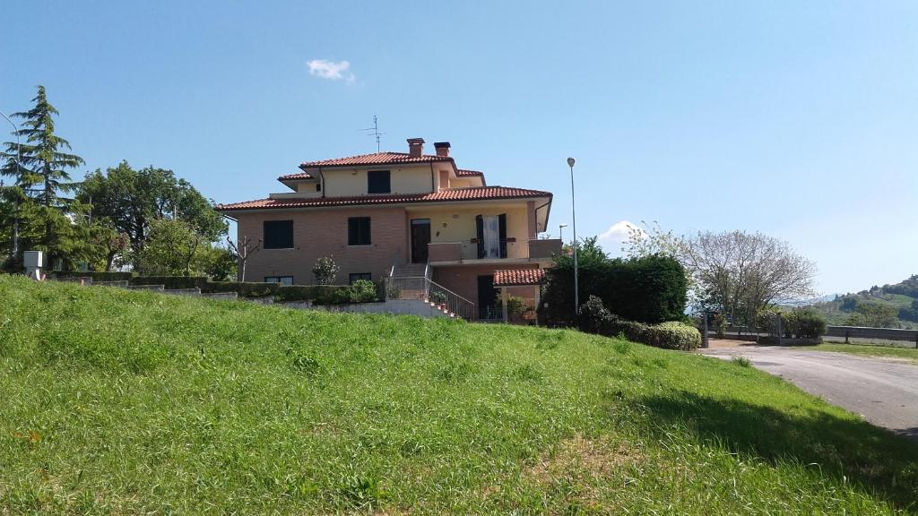 a house sitting on top of a grassy hill at B & B Il Sicomoro in Montecarotto