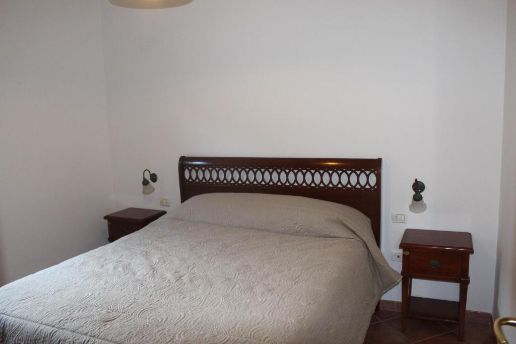 a bedroom with a bed with two nightstands and two tables at Residence Hotel Torresilvana in Vieste