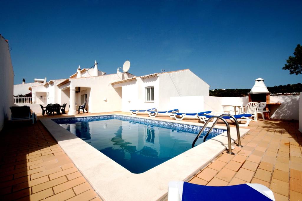 a swimming pool in front of a white house at Monte Sao Pedro - Villa in Luz