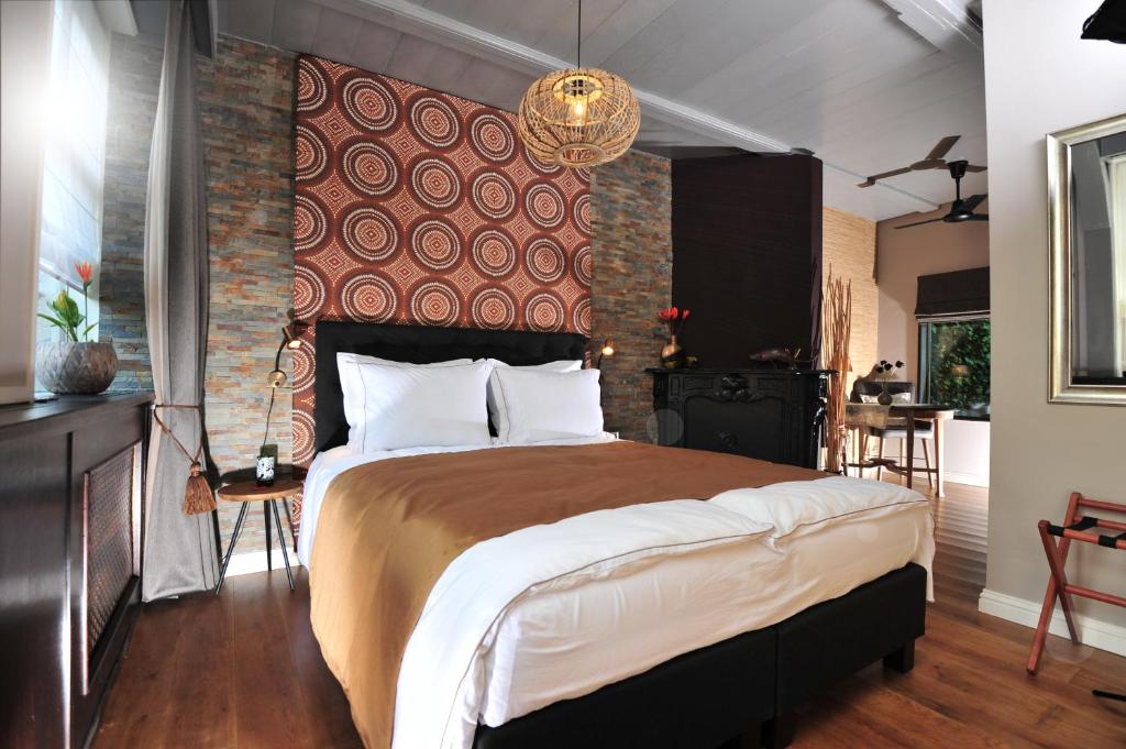 ein Schlafzimmer mit einem großen Bett mit Ziegelwand in der Unterkunft Agapanthus bed and breakfast in Hoogkarspel
