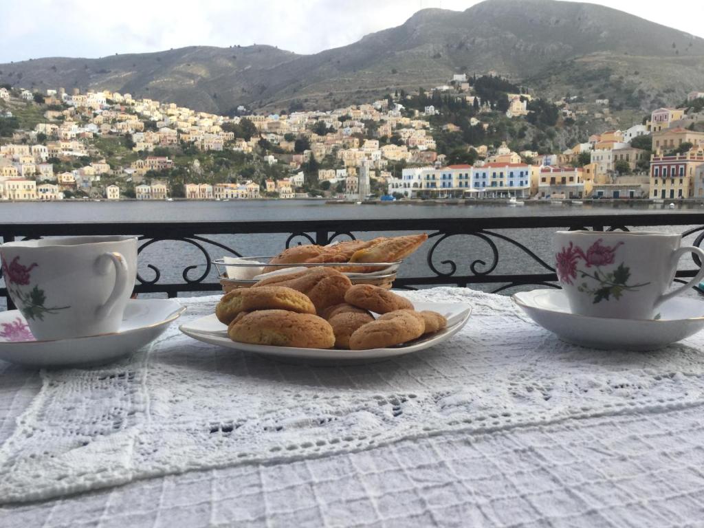 a table with plates of pastries and cups of coffee at Nikolitsi Studios in Symi