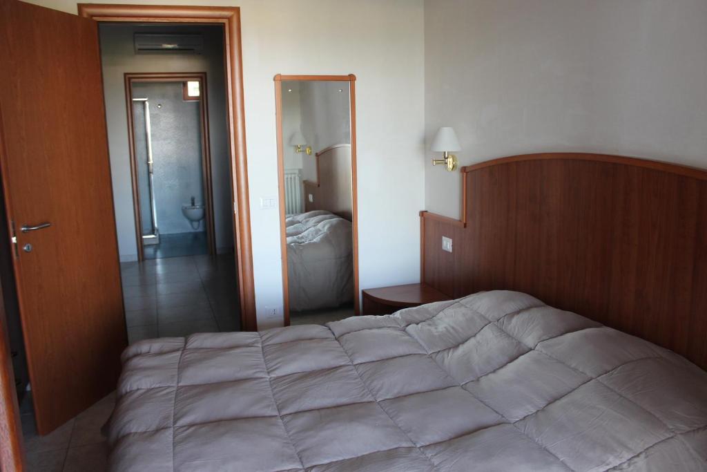 a bedroom with a large bed and a bathroom at Residence Hotel Torresilvana in Vieste