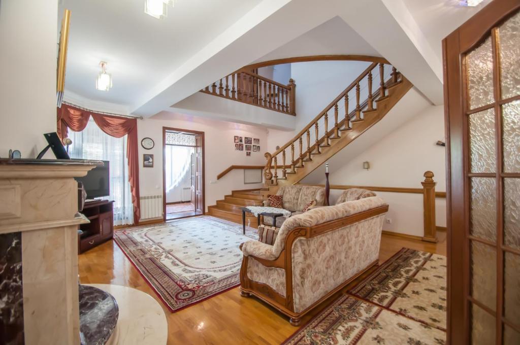 a living room with a couch and a staircase at Magnificent Villa in Chişinău