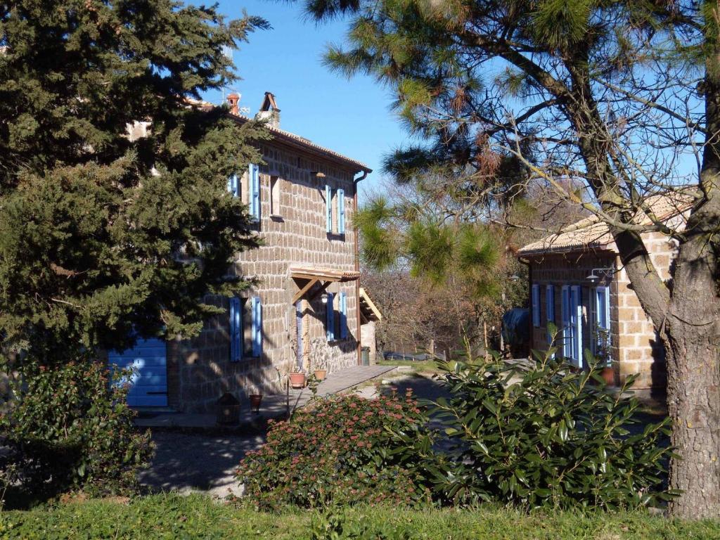 una casa con ventanas azules y un árbol en Podere Delle Rose, en Torre San Severo