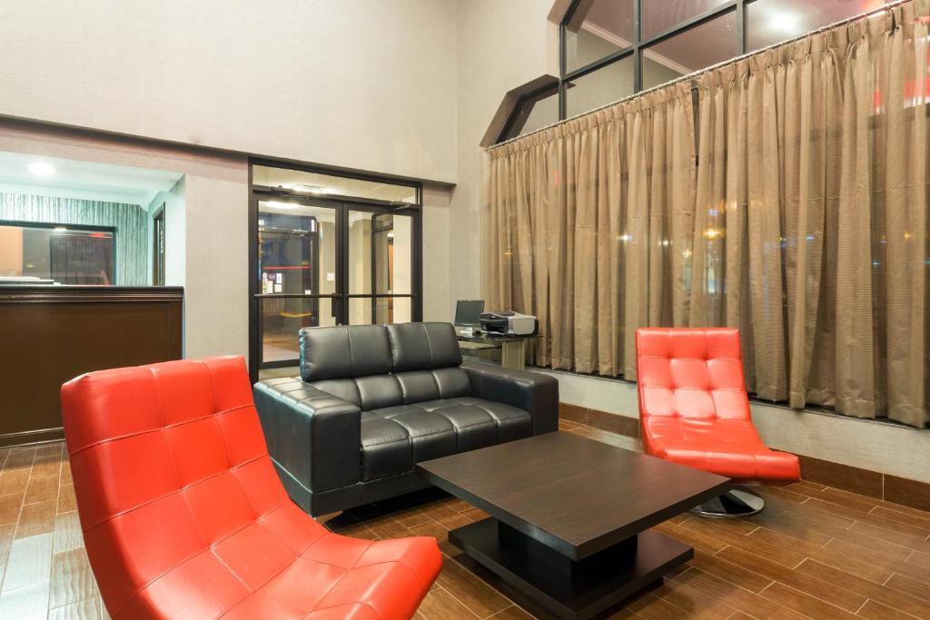 a waiting room with a leather couch and two chairs at Homestay Horn Lake Southaven in Horn Lake