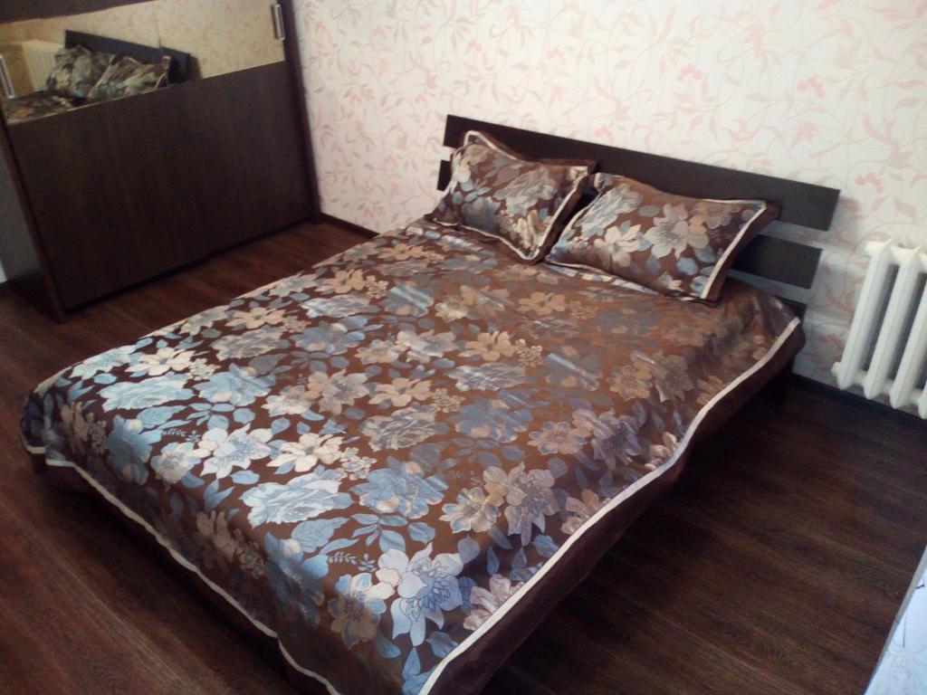 SalavatにあるАтмосфера Уютのベッドルーム1室(花柄の掛け布団付きのベッド1台付)