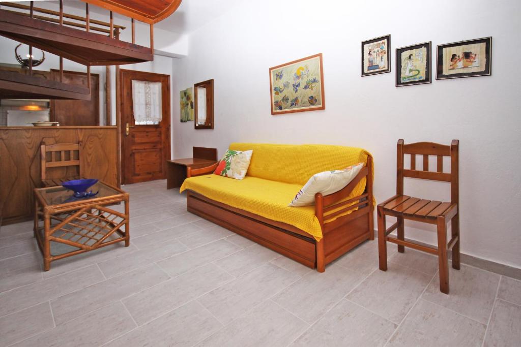 a living room with a yellow couch and chairs at Villa Angela in Vourvourou