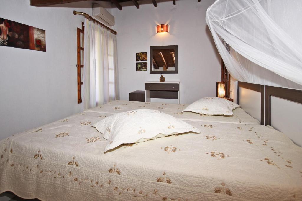 a bedroom with a large white bed with two pillows at Villa Angela in Vourvourou