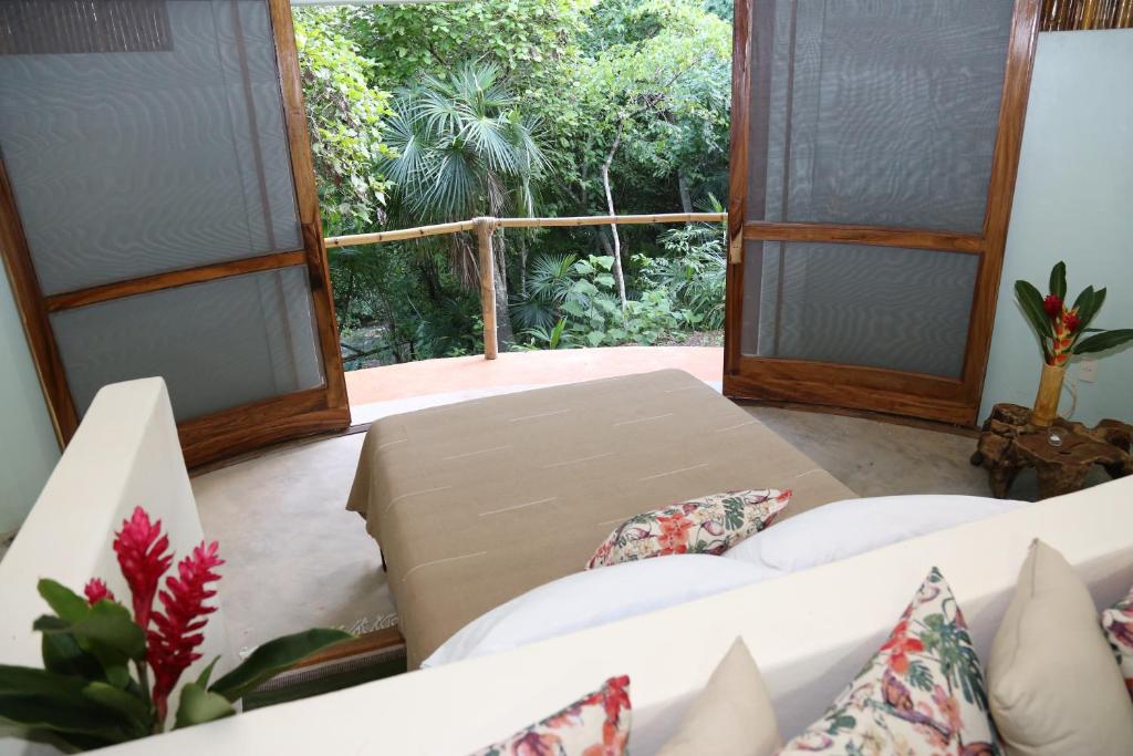 een woonkamer met een bank en een groot raam bij Cabañas Camino Mágico in San Miguel del Puerto