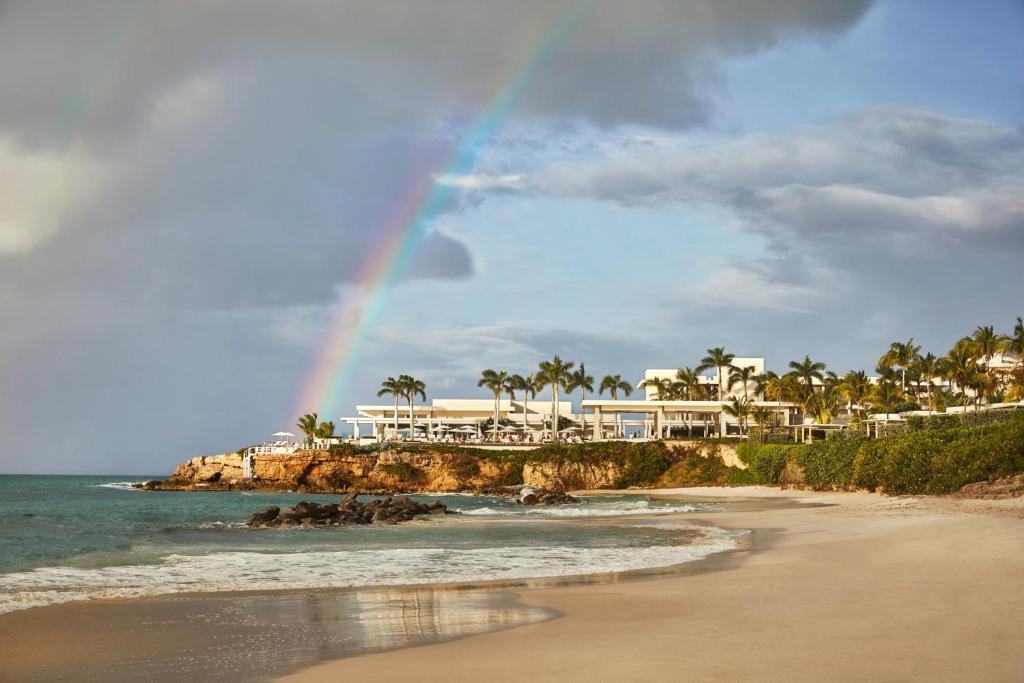 un arco iris sobre una playa con casas y el océano en Four Seasons Resort and Residences Anguilla en Meads Bay