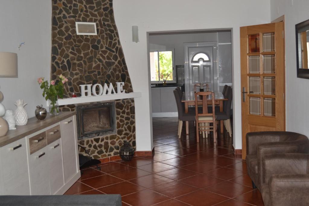 sala de estar con chimenea y comedor en casa de ferias, en Algoz