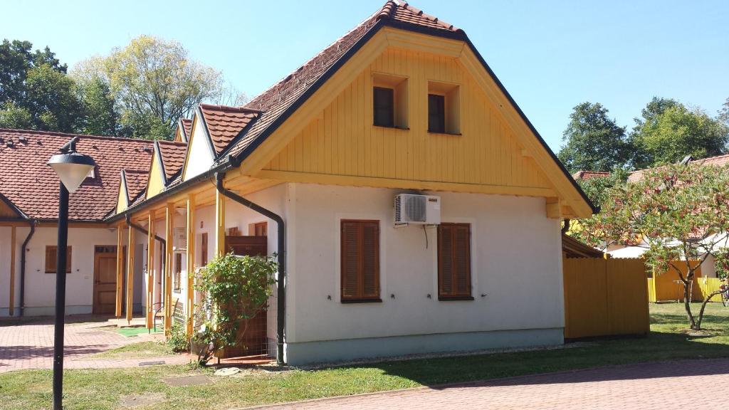 une petite maison blanche avec un toit jaune dans l'établissement Apartma TR 43, à Moravske Toplice