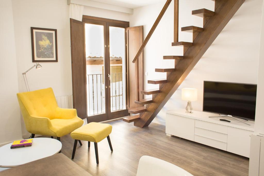 a living room with a staircase and a television at AiA EXCLUSIVE APARTMENTS in Granada