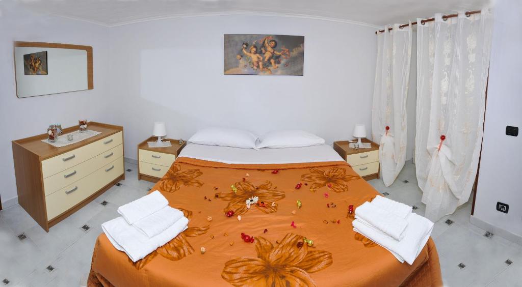 ナポリにあるWelcome Houseのベッドルーム1室(オレンジ色のベッドカバー付)