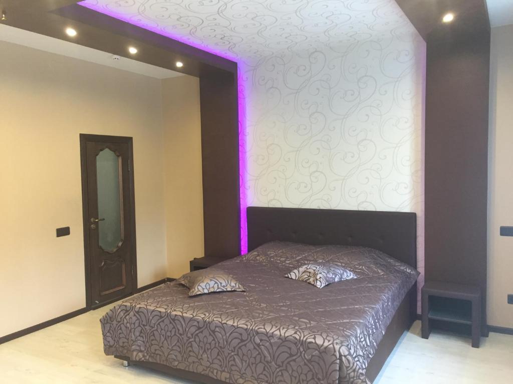 ヴォロネジにあるChasy na Planetnoyのベッドルーム1室(紫色の照明付きのベッド1台付)
