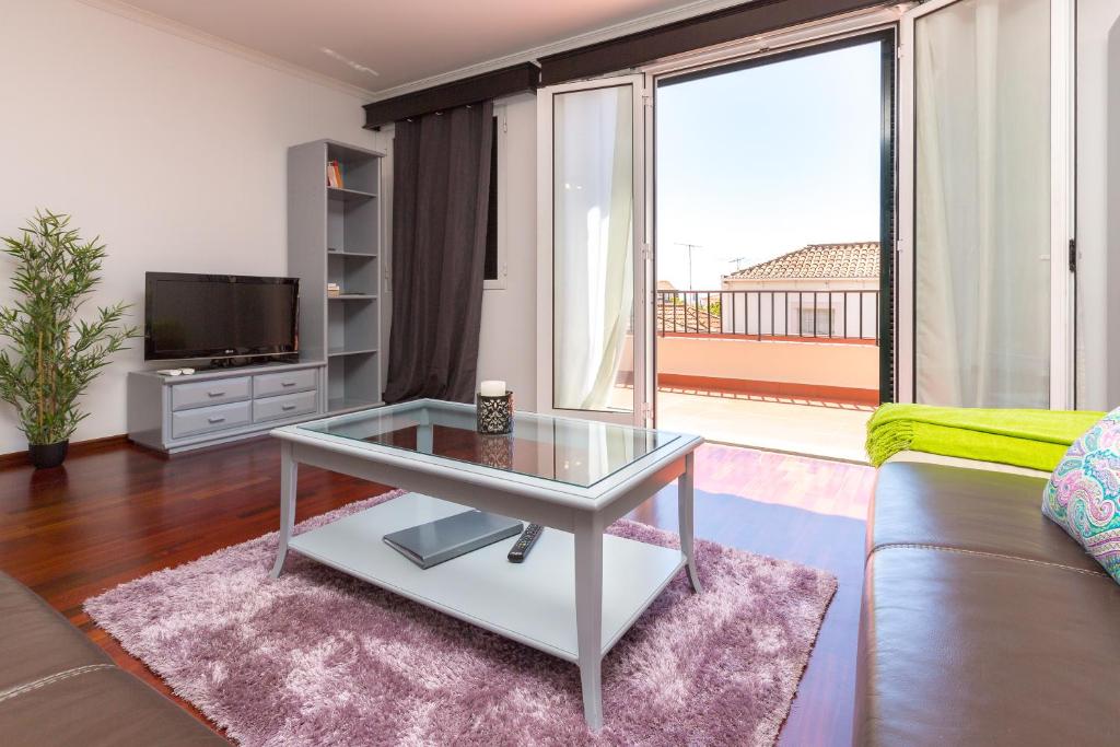 un soggiorno con tavolo in vetro e divano di Casa dos Avós by Rent2U, Lda a Funchal