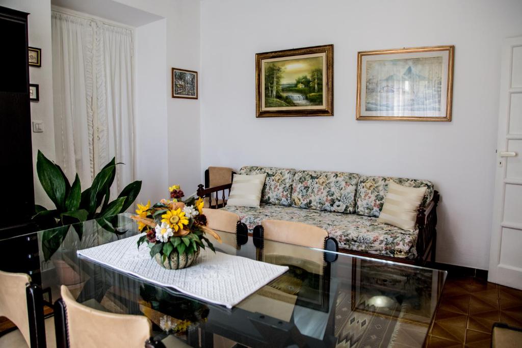 a living room with a couch and a table with flowers at Casa Fertilia in Fertilia