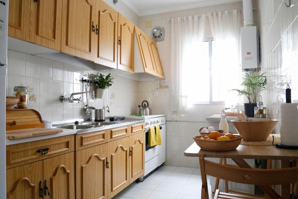 una cocina con armarios de madera y una mesa con un bol de fruta en Casa Las Nieves, en Arcos de la Frontera