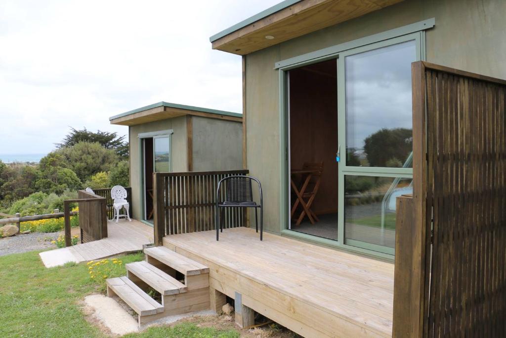 une terrasse en bois avec une chaise sur une maison dans l'établissement Riverton Holiday Park, à Riverton