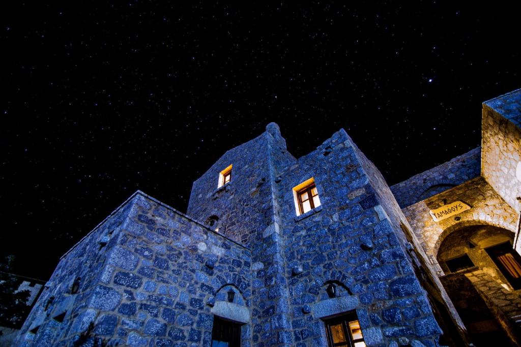a blue stone building with two windows at night at Psamathous Guesthouse in Pórto Káyio