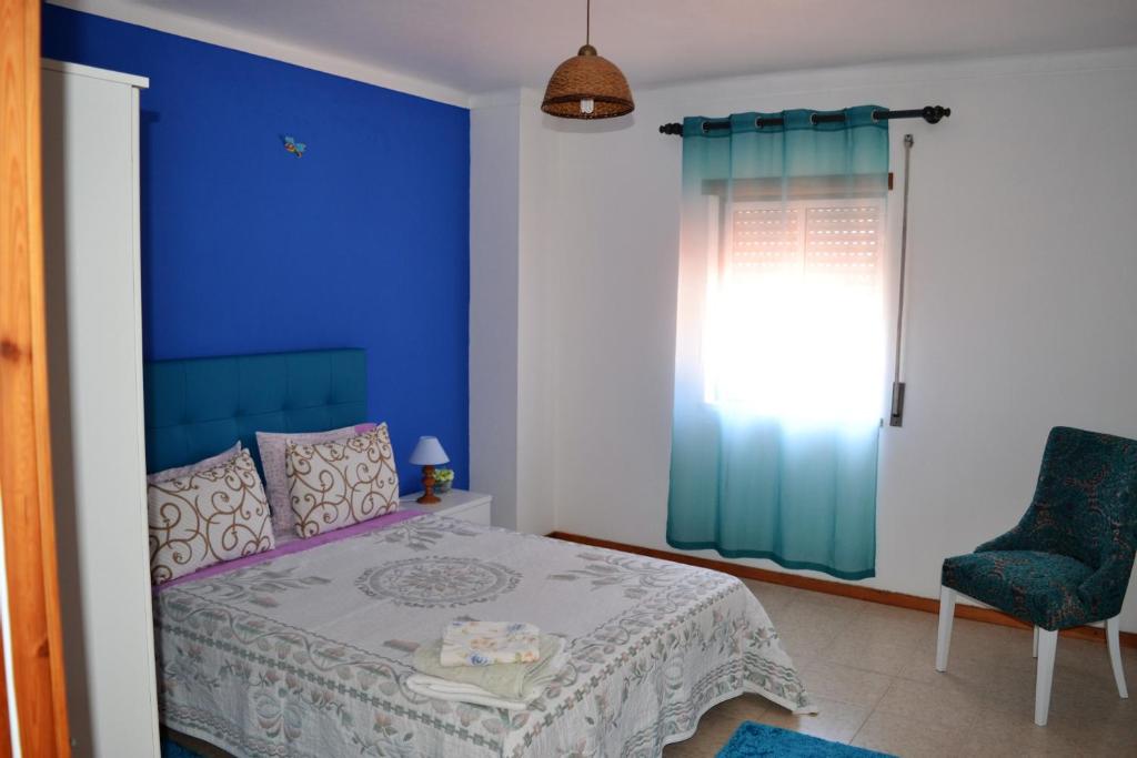 納扎雷的住宿－Ricardo Holidays At Nazaré，卧室拥有蓝色的墙壁,配有一张床和椅子