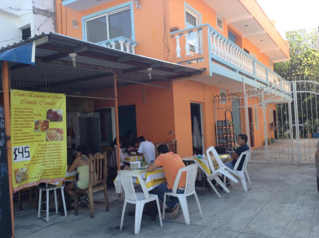 a group of people sitting at tables outside of a building at Roberto in Playa del Carmen