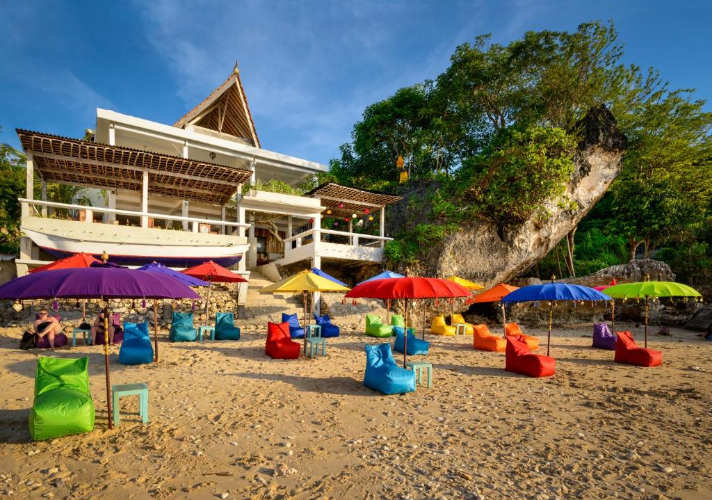 a beach with colorful chairs and umbrellas at The Point Beach-Front Balangan in Jimbaran