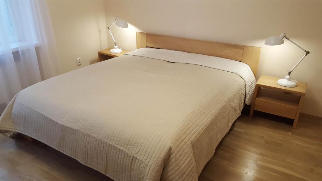 sypialnia z łóżkiem i 2 lampkami na stołach w obiekcie Apartment Katamaran w Krakowie