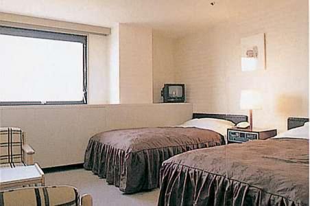 a hotel room with two beds and a window at Asahi Century Hotel in Minami Alps