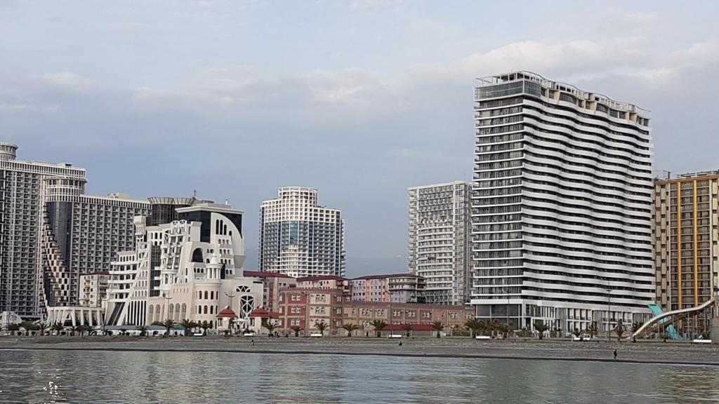 a city with tall buildings and a body of water at Family Apartment in Batumi