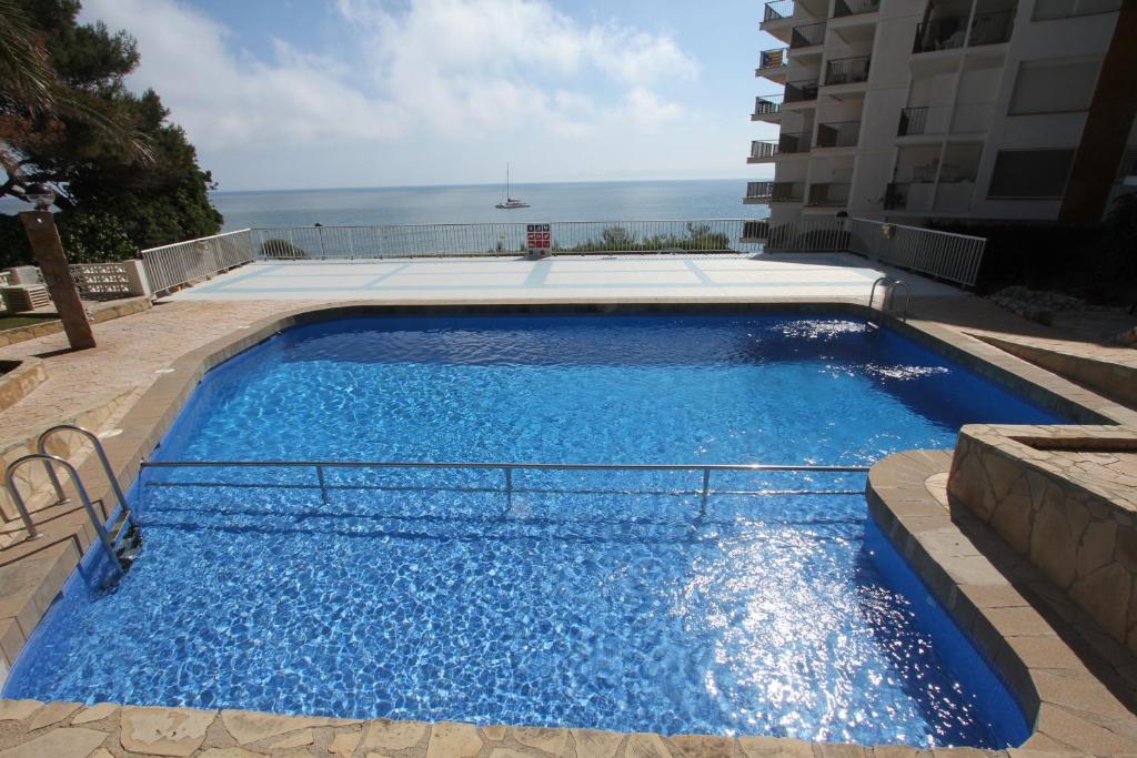 a large blue swimming pool next to a building at For a Stay Sant Jordi in Salou
