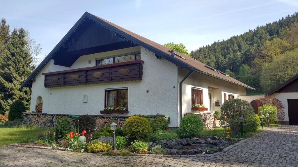 une maison blanche avec un toit en gambrel dans l'établissement Haus Annemarie, à Goldkronach