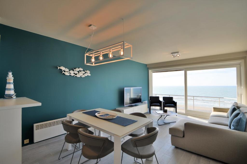 ニーウポールトにあるResidentie Scorpio B1の青い壁のリビングルーム(テーブル、椅子付)