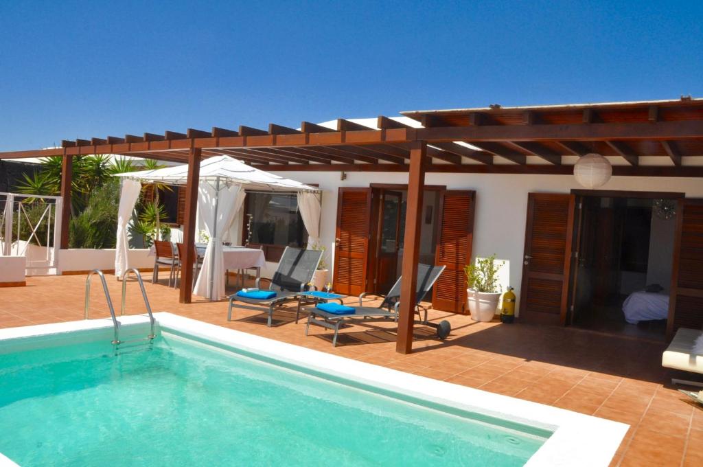 a house with a swimming pool and a pavilion at Happy Villa con piscina privada in Playa Blanca