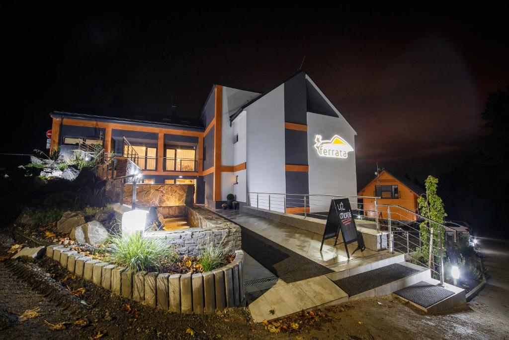 a house at night with a sign in front of it at Wellness Penzión Ferrata in Martin