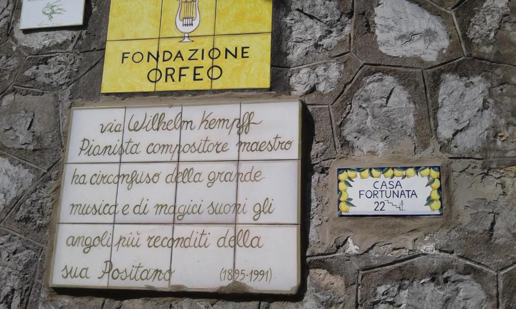 a stone wall with signs on it at Casa Fortunata in Positano