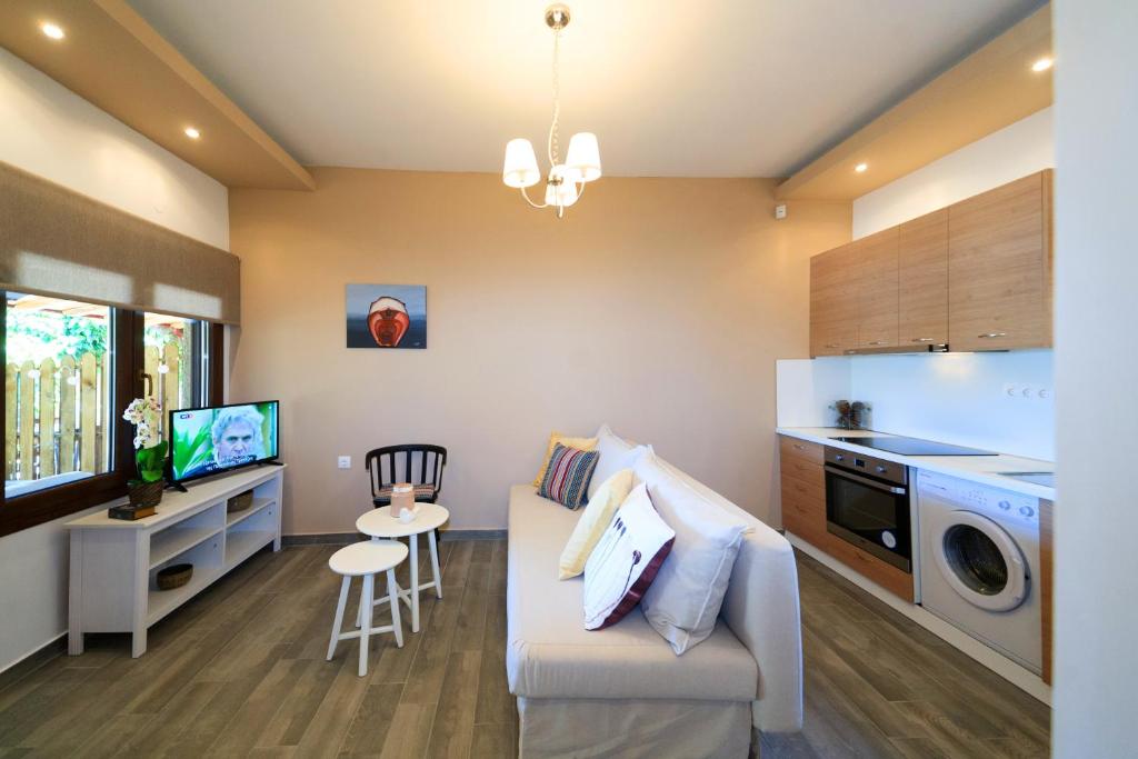 a small living room with a couch and a kitchen at Kissos Apartments in Vourvourou