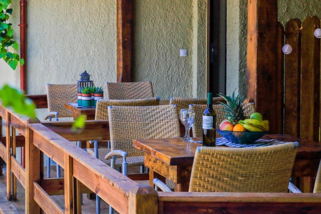 a table with a bowl of fruit and a bottle of wine at Kissos Apartments in Vourvourou