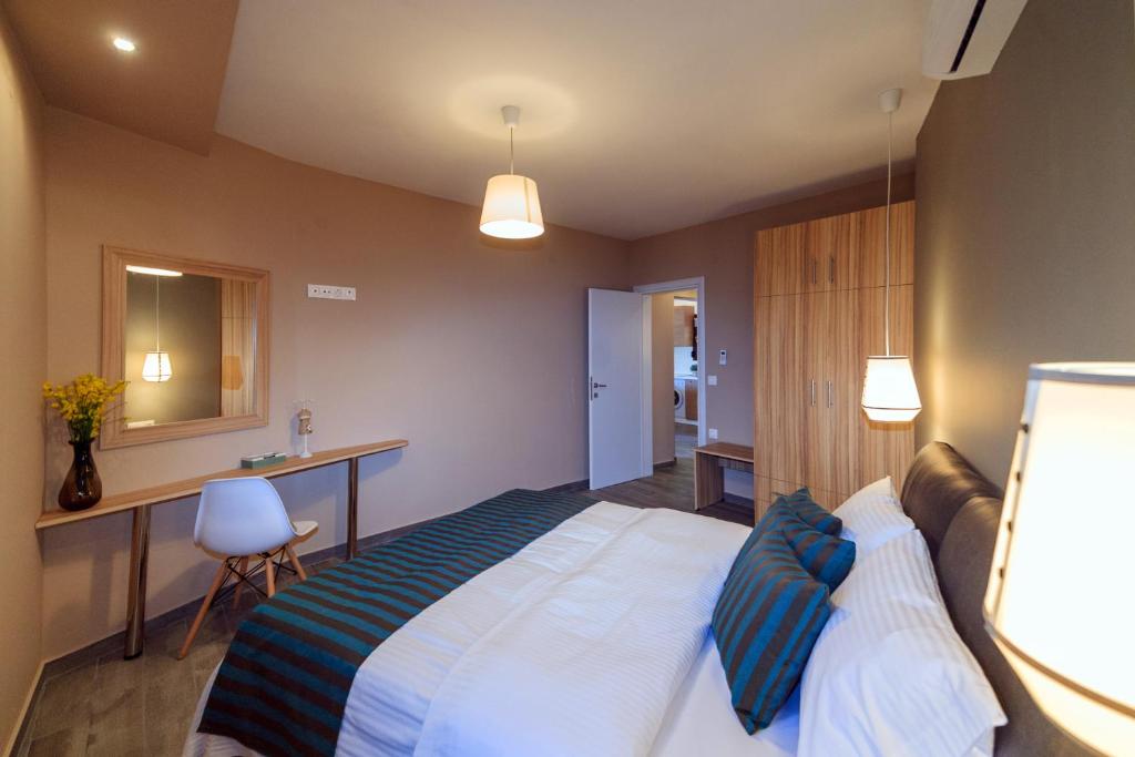 a hotel room with a large bed and a desk at Kissos Apartments in Vourvourou