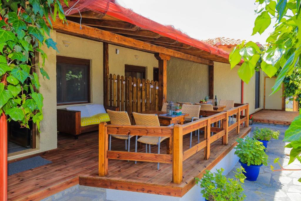 a wooden deck with a table and chairs on a house at Kissos Apartments in Vourvourou