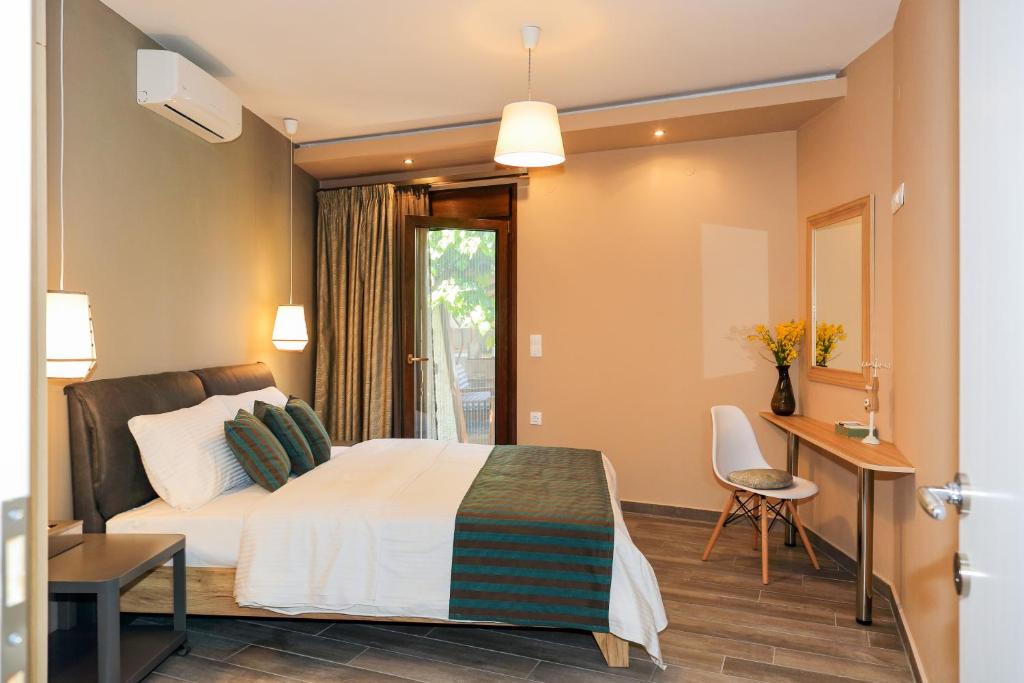 a bedroom with a bed and a table and a desk at Kissos Apartments in Vourvourou