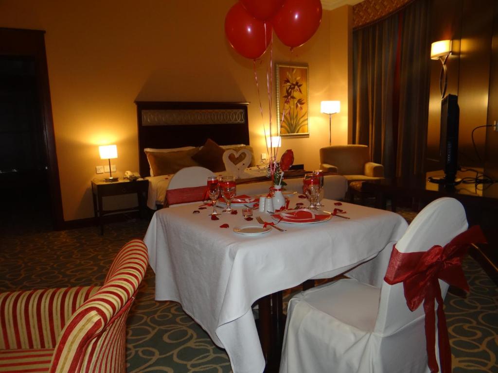 a room with a table and two chairs and a bed at Concorde Hotel Fujairah in Fujairah
