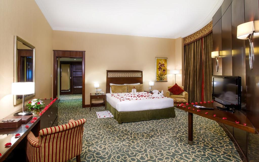 a hotel room with a bed and a television at Concorde Hotel Fujairah in Fujairah