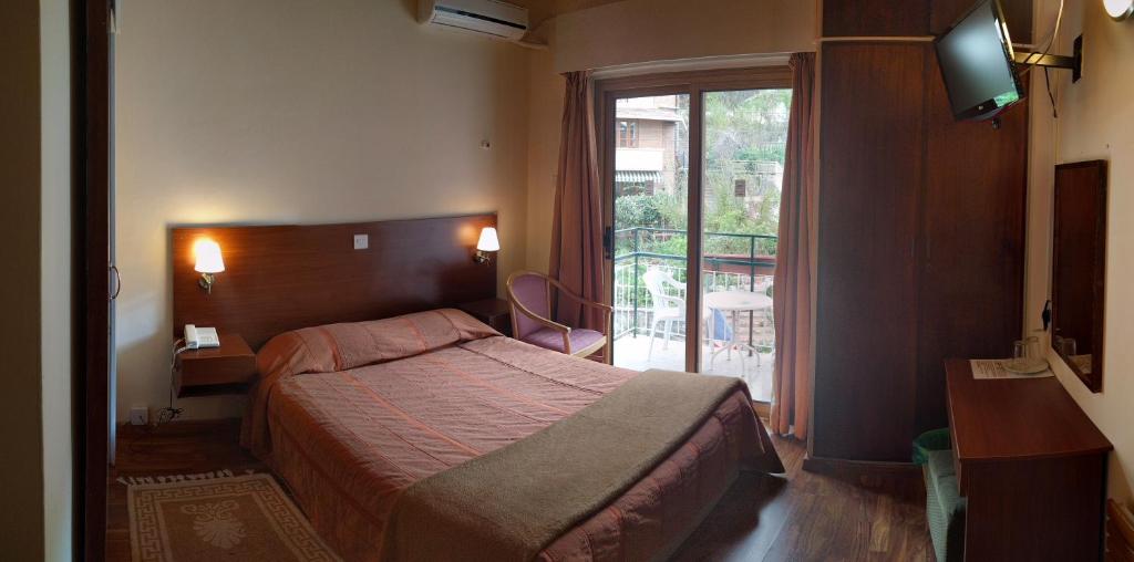 a hotel room with a bed and a balcony at Edelweiss Hotel in Platres