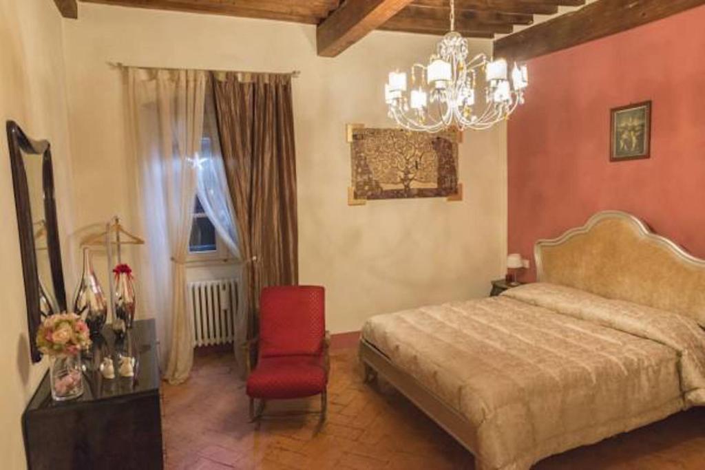 een slaapkamer met een bed en een rode stoel bij La Terrazza in Poppi