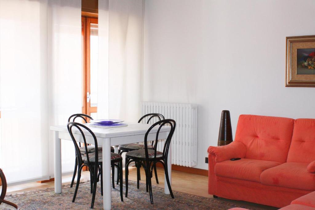 jadalnia ze stołem, krzesłami i kanapą w obiekcie Appartamenti Mori w mieście Belluno