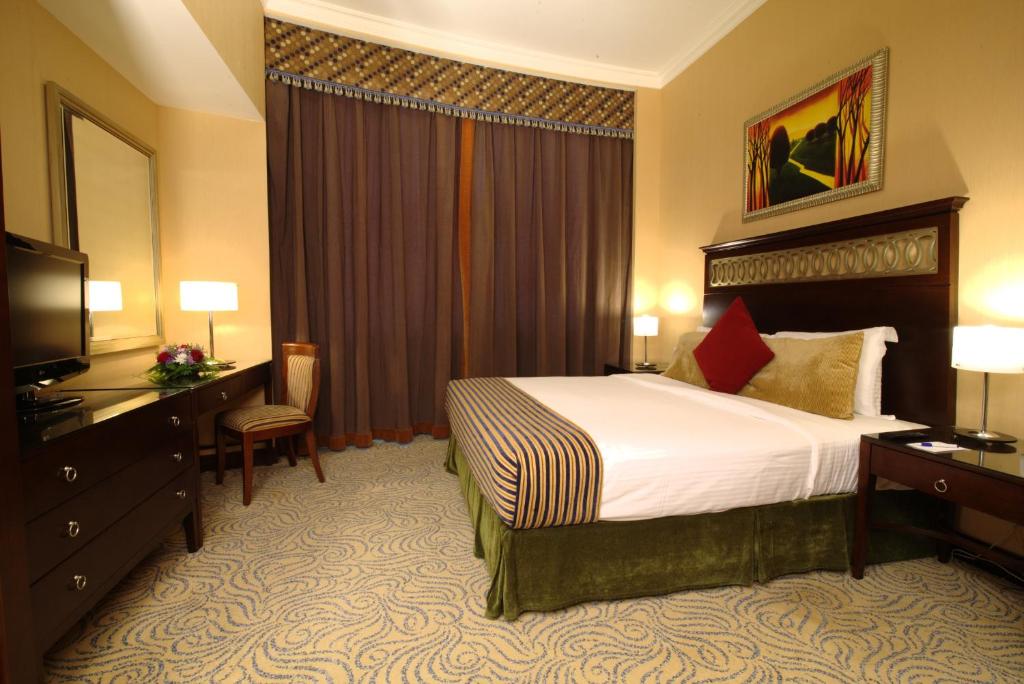 a hotel room with a bed and a television at Concorde Hotel Fujairah in Fujairah